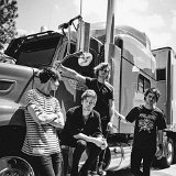5 Seconds of Summer  Band members posed with a truck. Calum Hood is wearing black high top chucks.