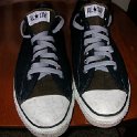 Brad Deniston Collection of Chucks  Top view of black low cuts with grey shoelaces.