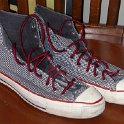 Brad Deniston Collection of Chucks  Angled side view of grey checkered print high tops with red trim and laces.