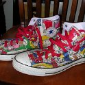 Brad Deniston Collection of Chucks  Angled side view of comic print high tops with red shoelaces.
