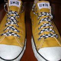 Brad Deniston Collection of Chucks  Top view of gold low cut chucks with black and white checkered laces.