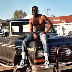 Buddy  A shirtless Buddy seated on a truck, short 2.