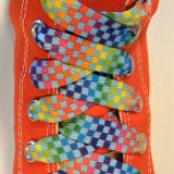 Rainbow Checkered Print Shoelaces On Chucks  Rainbow checkered print shoelace on an orange high top chuck.