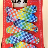 Rainbow Checkered Print Shoelaces On Chucks  Rainbow checkered print shoelace on a red low top chuck.