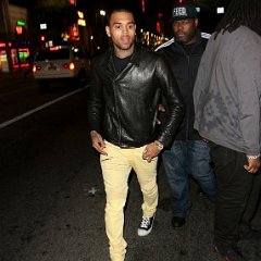Chris Brown  Chris Brown wearing black chucks while walking down the street with his entourage.
