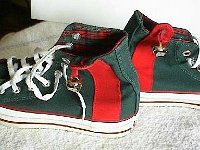 Christmas High Top Chucks  Side view of green and red 2 tone showing bell, red side strip, bell, and plaid interior.