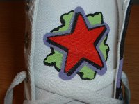 Chucks With Custom Print Pattern Uppers  Closeup of the star graphic on the tongue of a white graffiti high top.
