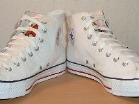 Chucks With Custom Print Pattern Uppers  Angled front views of white graffiti high tops.