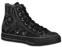 Denim Chuck Taylors  Angled inside patch view of a left black denim high top chuck with white stitched details.