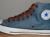 Denim Chuck Taylors  Inside patch view of a right light blue coated denim high top with brown laces.