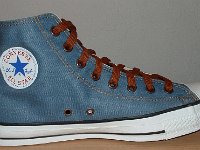 Denim Chuck Taylors  Inside patch view of a left light blue coated denim high top with brown laces.