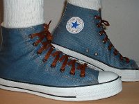 Denim Chuck Taylors  Wearing light blue coated denim high tops with brown shoelaces, side view.