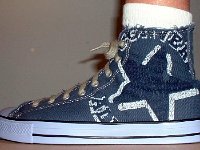 Denim Chuck Taylors  Wearing blue denim graphic star high tops, left outside view.