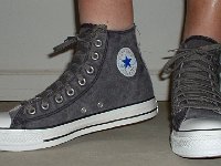 Distressed High Top Chucks  Wearing distressed black high top chucks, angled front view.