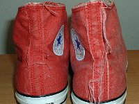 Distressed High Top Chucks  Rear view of distressed red high tops, showing dangling threads are rear patch.