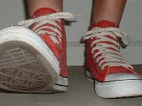 Distressed High Top Chucks  Stepping out in distressed red high top chucks, front view.