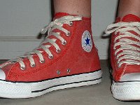 Distressed High Top Chucks  Wearing distressed red high tops, angled front view.