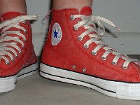 Distressed High Top Chucks  Wearing distressed red high top chucks, angled front view.