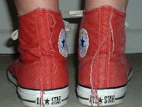 Distressed High Top Chucks  Wearing distressed red high top chucks, rear view.