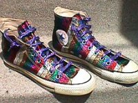 Chucks with Geometric Pattern Uppers  Striped pattern high tops with glitter and purple laces. Angled side view.