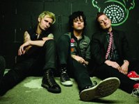 Green Day  Casual shot of the band before a performance. Billie Joe is wearing black low cut and Tre Cool is wearing red high top chucks.