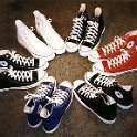 Group Shots of Chucks  Six pairs of high top chucks in a circle, including 3 black, 1 blue, 1 optical white, and 1 red.
