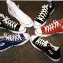 Group Shots of Chucks  Top view of a circle of single high top chucks, in black, blue, optical white, and red.