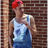 Guys Wearing Red Chucks  Guy wearing red high top chucks with torn blue jean overalls, a white print tank top, and red baseball cap.