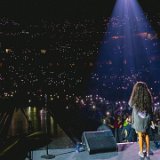 Jessie Reyez  A sea of lights listens intently to Jessie as she performs in grey high top chucks.