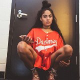 Jessie Reyez  Jessie wearing red high top chucks and a red baseball jersey.