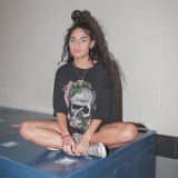 Jessie Reyez  Jessie wearing a grey skull t-shirt with grey high top chucks.