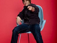 Justin Bieber  Justin Bielber seated wearing optical white high top chucks.
