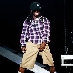 Lil Wayne  Lil Wayne wearing black high top chucks with the tag still on.