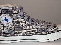 Chucks With Repeated Logo Pattern Uppers  Inside patch view of a left black and white heel patch print high top with gray shoelaces.