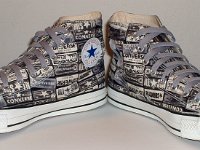 Chucks With Repeated Logo Pattern Uppers  Angled front views of black and white heel patch print high tops with gray shoelaces.