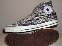 Chucks With Repeated Logo Pattern Uppers  Inside patch and sole views of black and white heel patch print high tops with gray shoelaces.