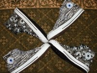 Chucks With Repeated Logo Pattern Uppers  Top view of a sideways wheel of black and white Chuck Taylor logo patch print high tops.