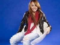 Miley Cyrus  Miley seated wearing black high top chucks.