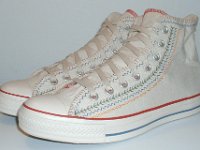 Multicultural High Top Chucks  Angled side view of parchment with red, blue, and orange trim multicultural high tops.