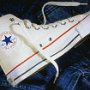 Optical White High Top Chucks  Left optical white high top, inside patch view over blue jeans.