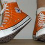 Orange Chucks  Stepping out in orange high tops, front view.