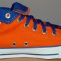 Orange Chucks  Inside patch view of a left orange and royal blue high top rolled down to the seventh eyelet.