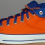 Orange Chucks  Outside view of a left orange and royal blue high top rolled down to the seventh eyelet.