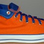 Orange Chucks  Outside view of a right orange and royal blue high top rolled down to the seventh eyelet.