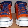 Orange Chucks  Front view of orange and royal blue high tops rolled down to the seventh eyelet.