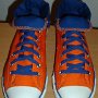 Orange Chucks  Angled front and top view of orange and royal blue high tops rolled down to the seventh eyelet.