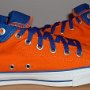 Orange Chucks  Inside patch views of orange and royal blue high tops rolled down to the seventh eyelet.