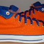 Orange Chucks  Outside views of orange and royal blue high tops rolled down to the seventh eyelet.