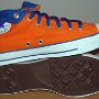 Orange Chucks  Sole and inside patch views of orange and royal blue high tops rolled down to the seventh eyelet.