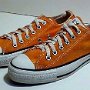 Orange Chucks  Vermillion low cuts, made in USA, angled side view.
